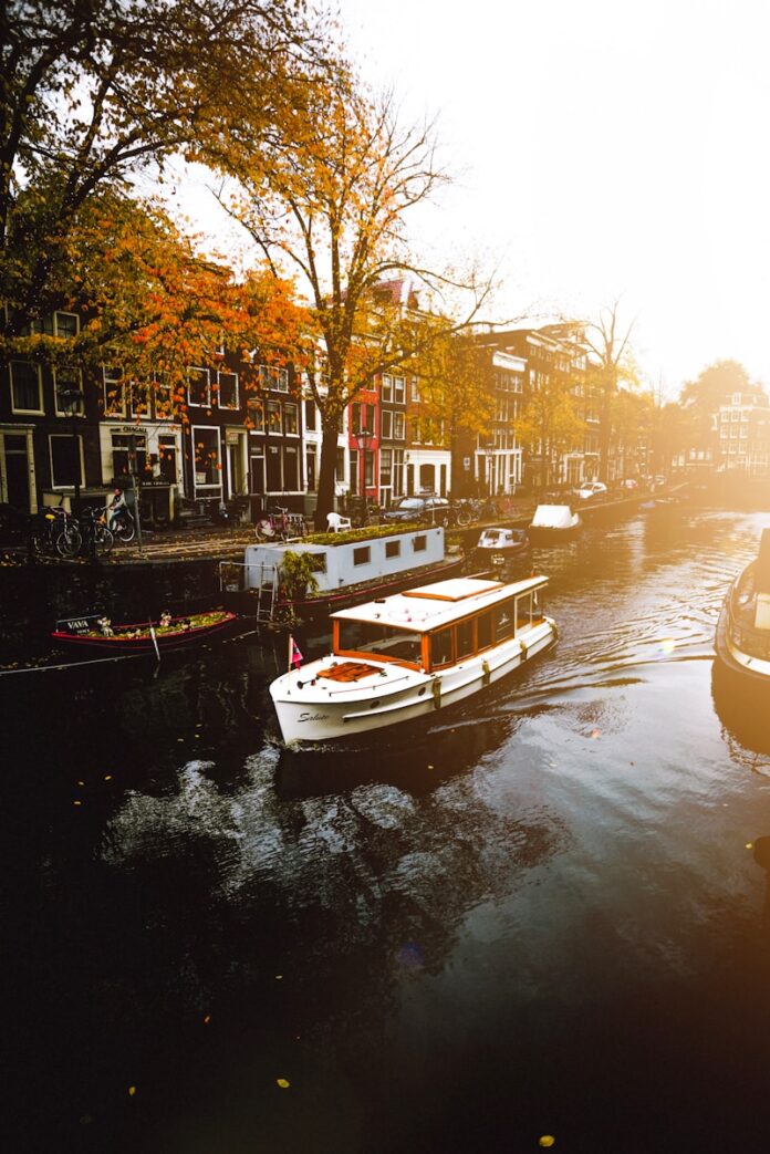 white boat on body of water near buildings during daytime, Amsterdam