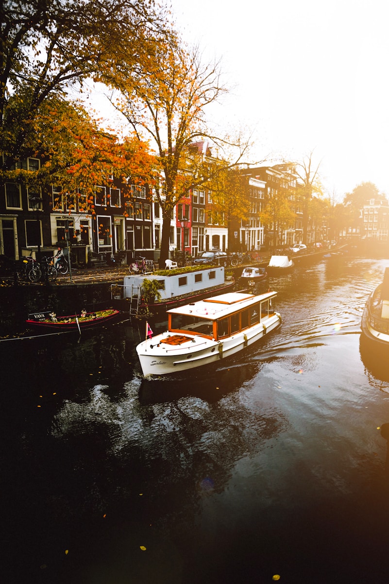 white boat on body of water near buildings during daytime, Amsterdam