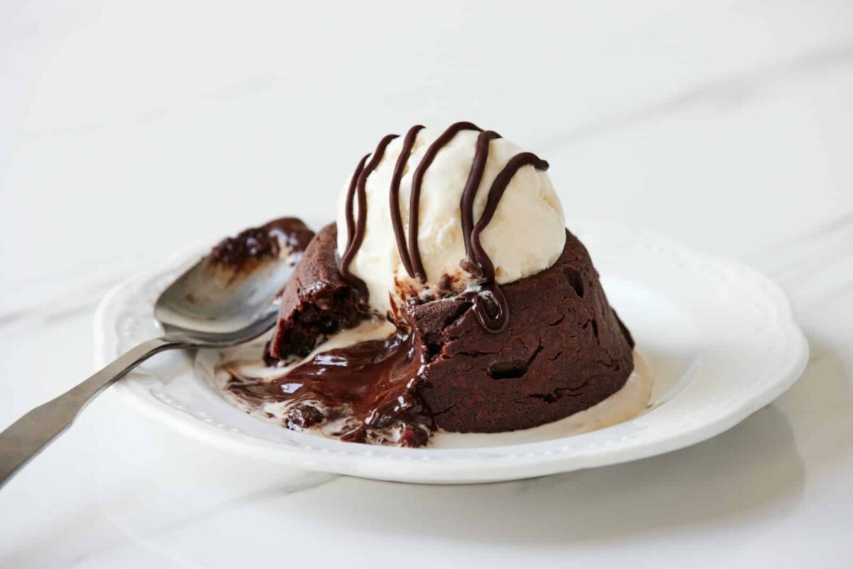 a white plate topped with a piece of cake and ice cream, chocolate lava cake