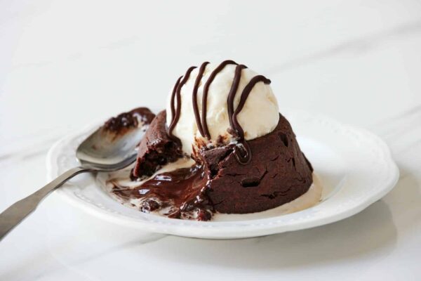 a white plate topped with a piece of cake and ice cream, chocolate lava cake