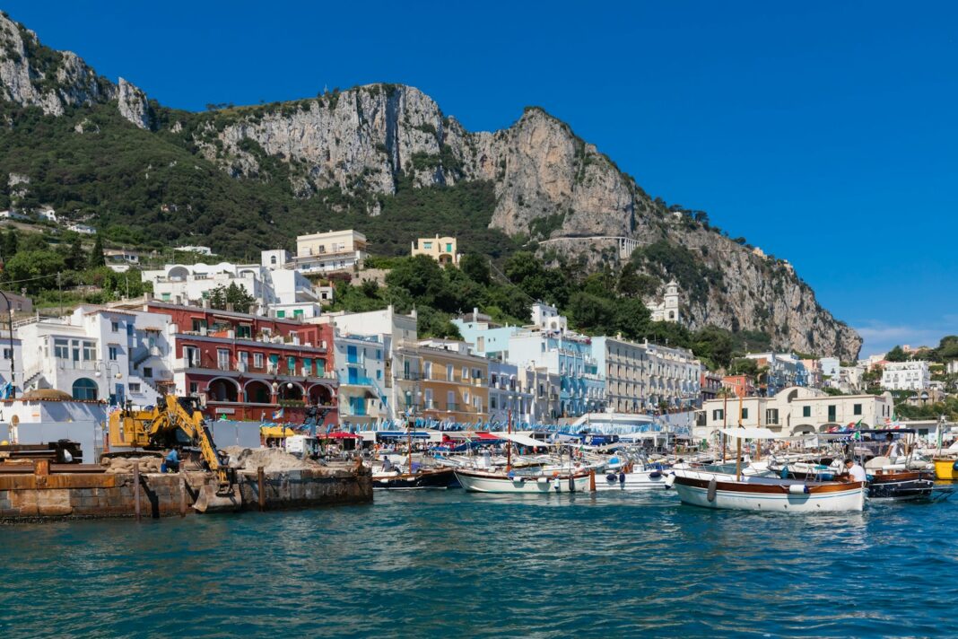 a harbor filled with lots of boats next to a mountain