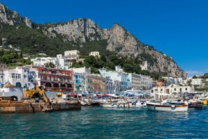 a harbor filled with lots of boats next to a mountain