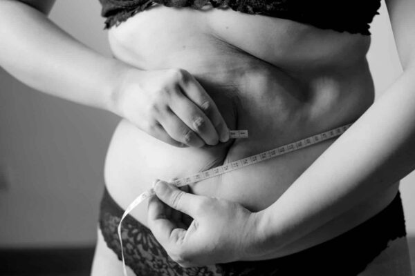 yo-yo dieting, grayscale photo of woman holding her breast