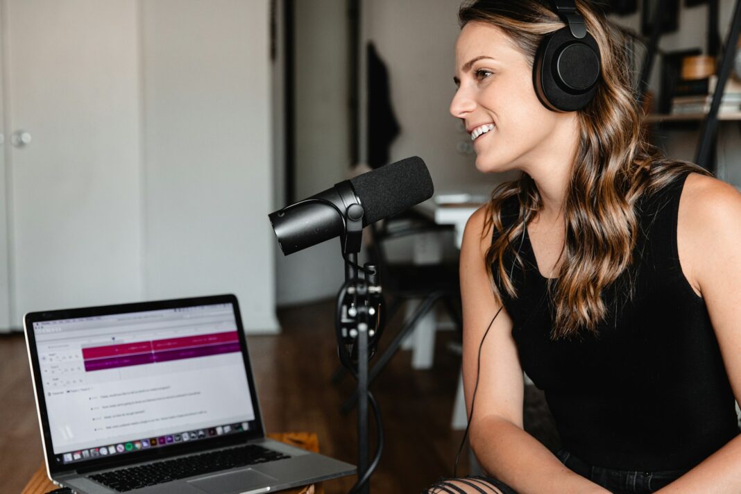 woman in black tank top sitting on chair in front of microphone, do a podcast