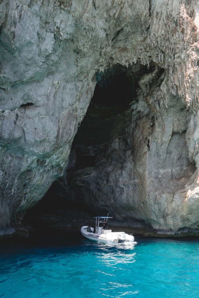 white speed boat near rock formation