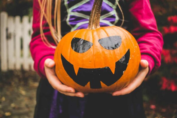 Trick-or-Treating -selective focus photography of person holding pumpkin