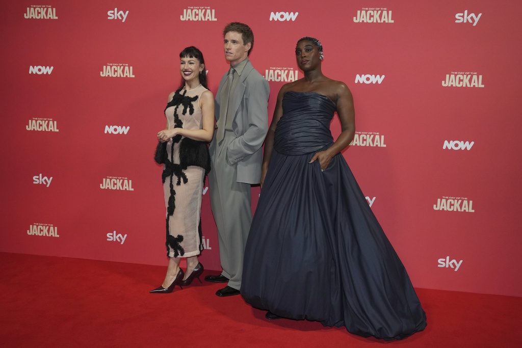 From left, Spanish actress Ursula Corbero, British actor Eddie Redmayne and British actress Lashana Lynch pose for photos on the red carpet at the 