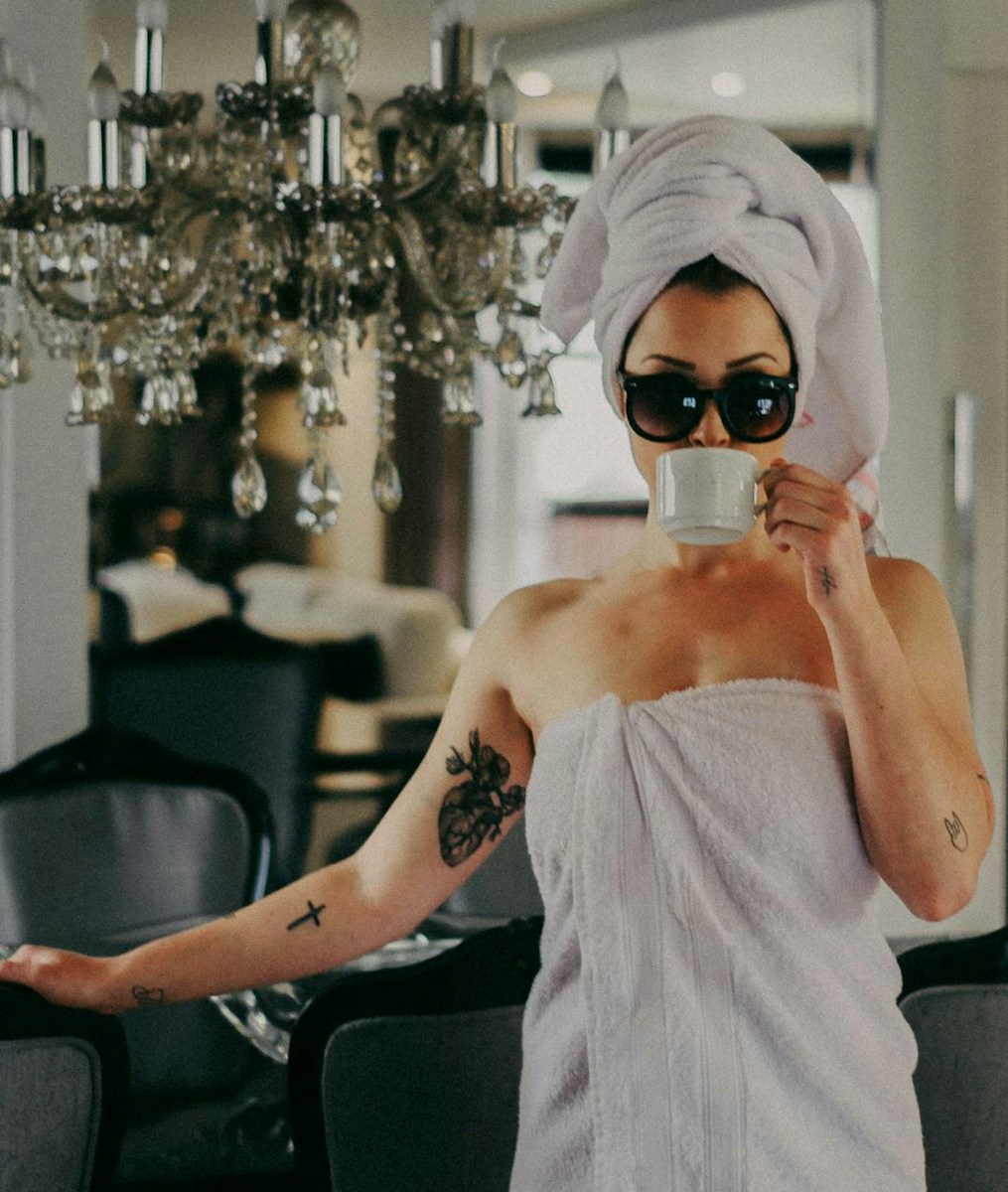 Fasting, woman holding mug and wearing towel and sunglasses holding hcair