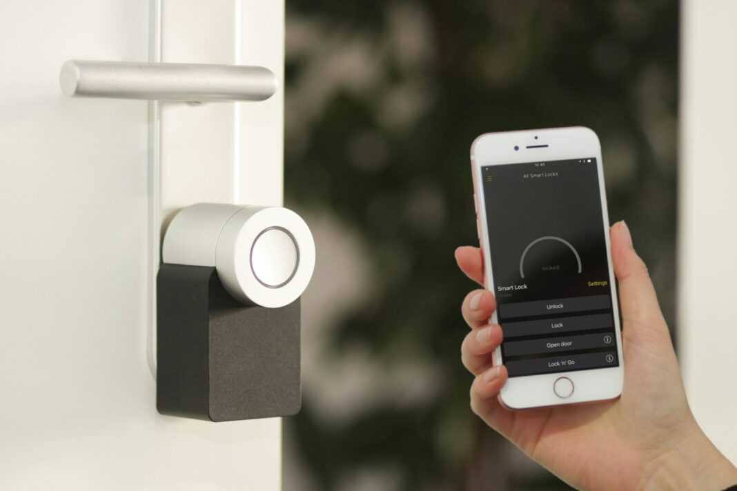 Homesecurity, gold Apple iPhone smartphone held at the door