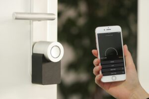 Homesecurity, gold Apple iPhone smartphone held at the door