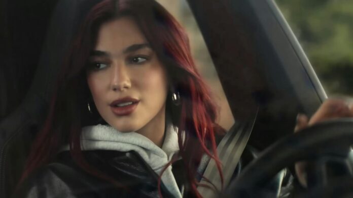 Dua Lipa sits in a Porsche Macan Electric