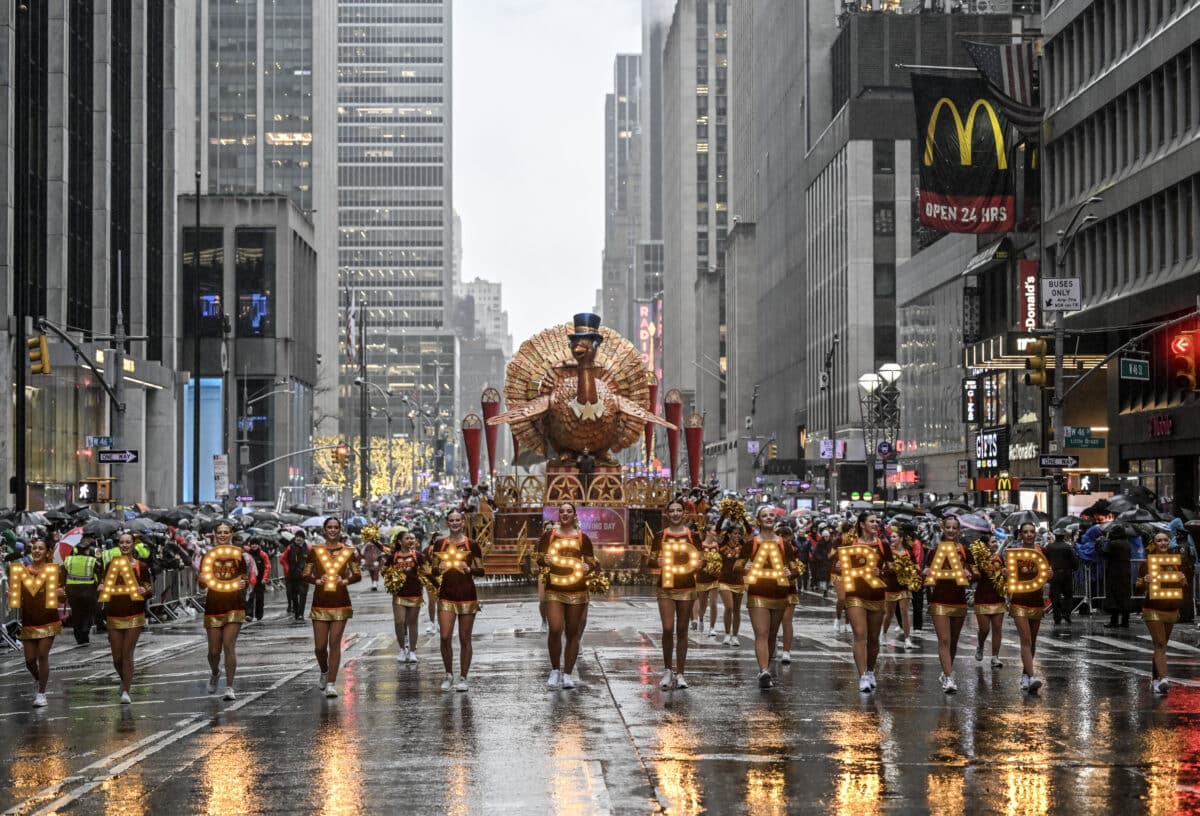 NEW YORK, NY - NOVEMBER 28: The traditional Thanksgiving bird float leads the Macy's Thanksgiving Day Parade with performers holding illuminated letters spelling 'Macy's Parade,' as large balloons, including Minnie Mouse, follow behind on a rainy day in New York, United States on November 28, 2024 (Photo by Fatih Aktas/Anadolu via Getty Images)