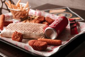 10 Reasons Why Processed Food - red and white coca cola can beside brown bread on white ceramic plate