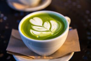 Drinking Too Much Matcha - white ceramic teacup filled of matcha tea