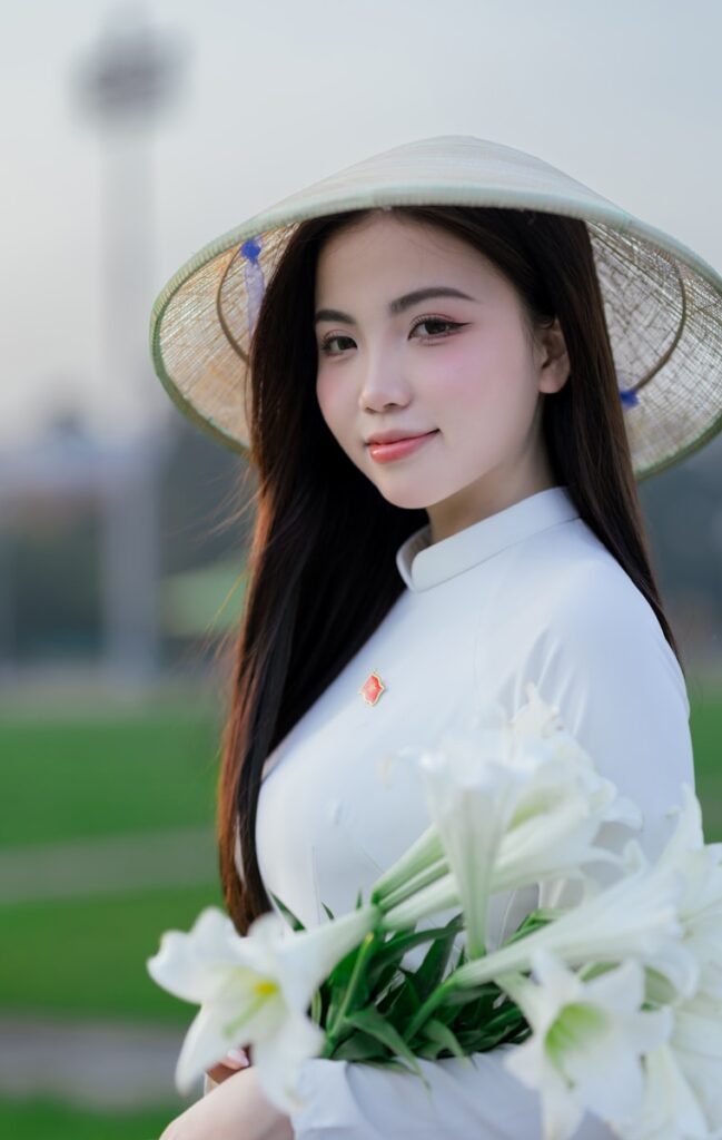 asian skincare, A woman in traditional vietnamese attire smiles.