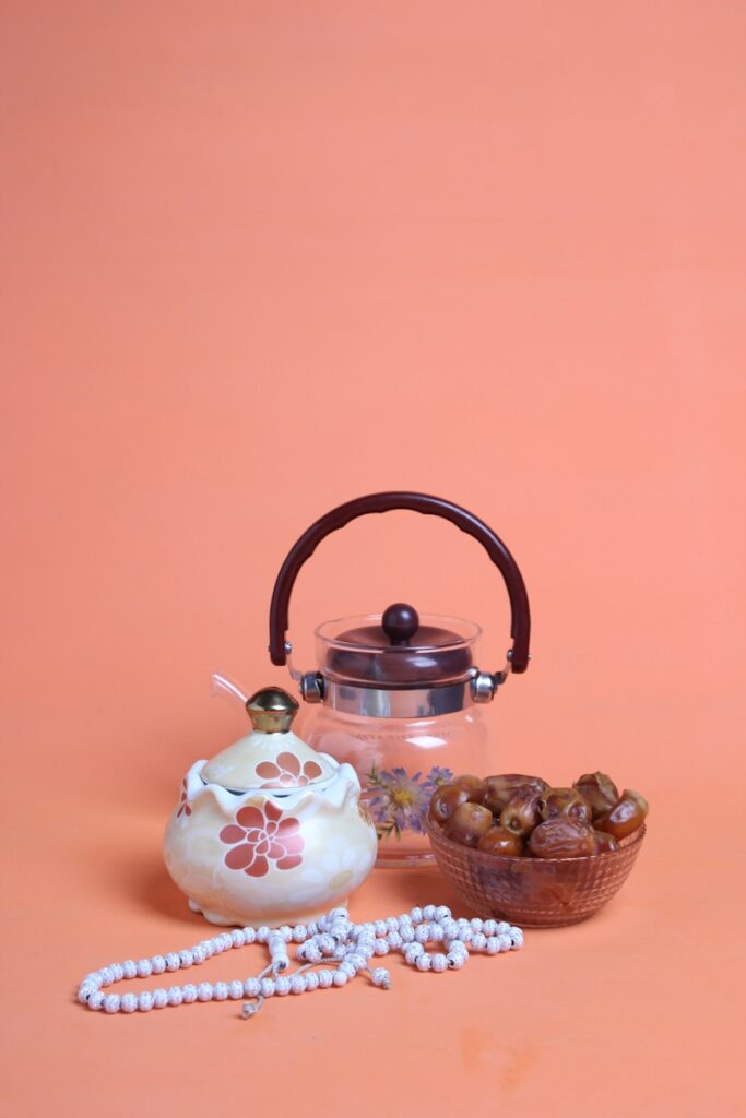 fasting, a tea kettle and a bowl of nuts on a pink background