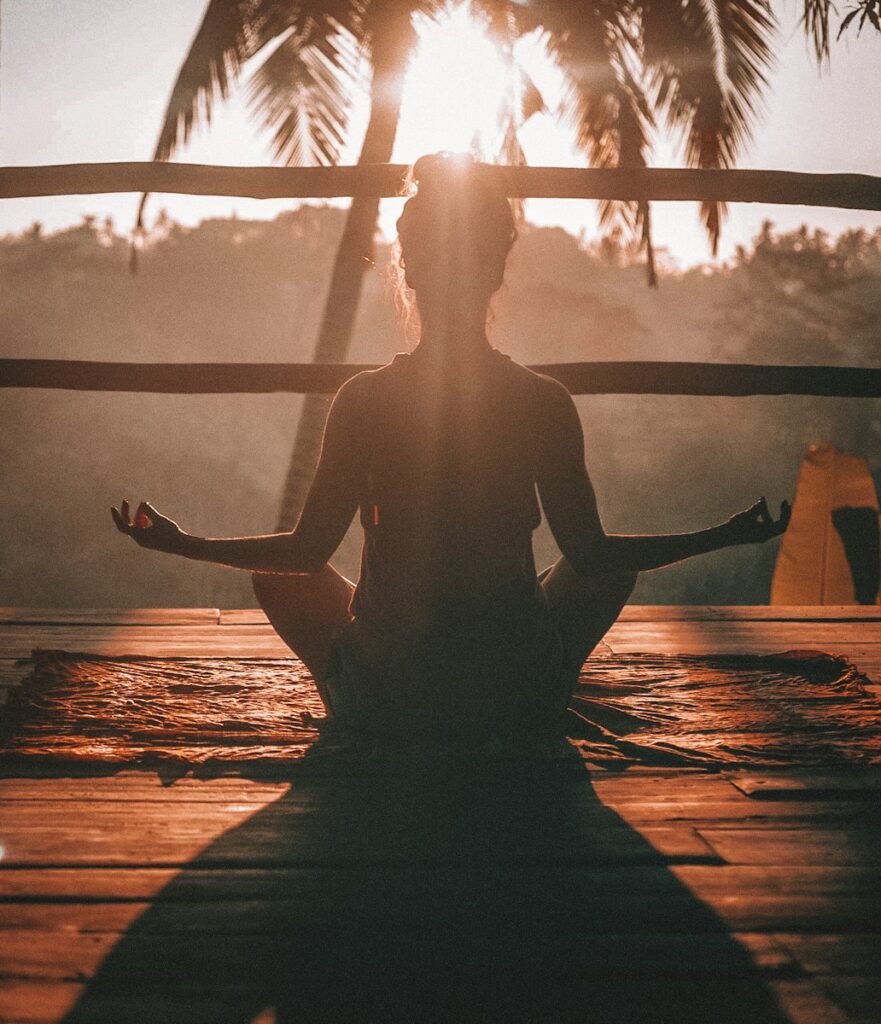 7 chakras, woman doing yoga meditation on brown parquet flooring