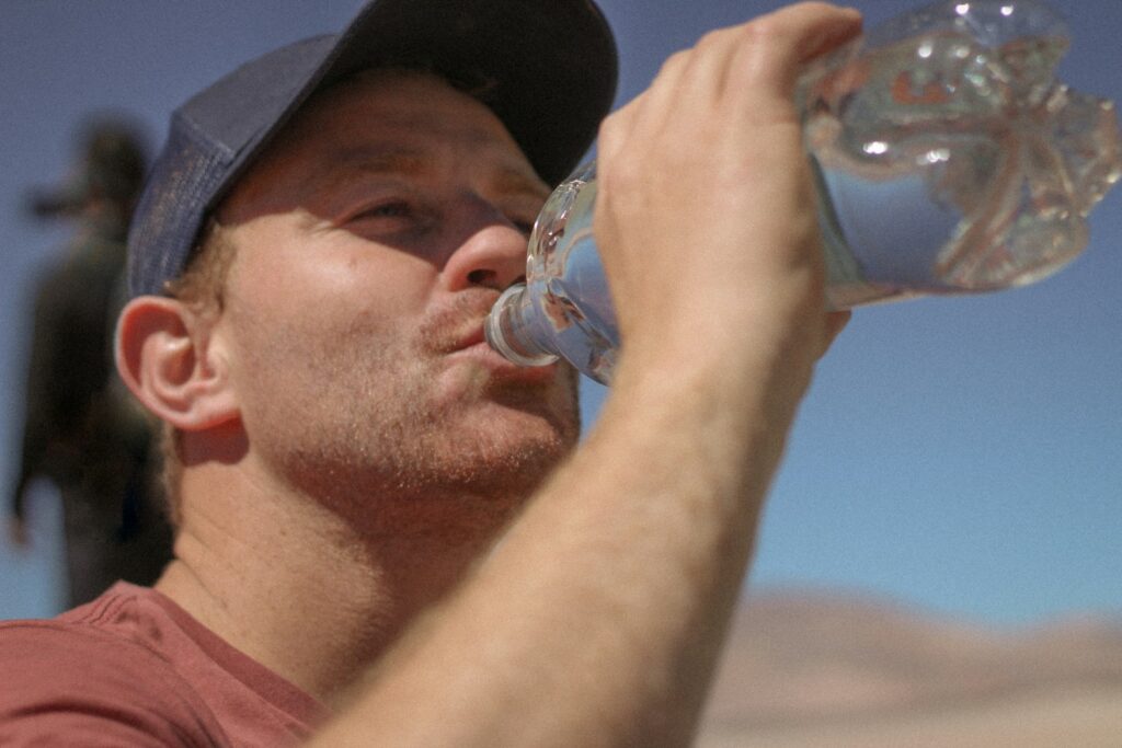 water, a man drinking water out of a bottle