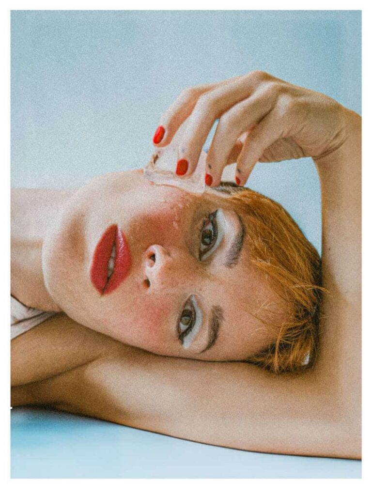 face plunge  ice cube Creative portrait of a woman in a vintage style with ice and red accents.