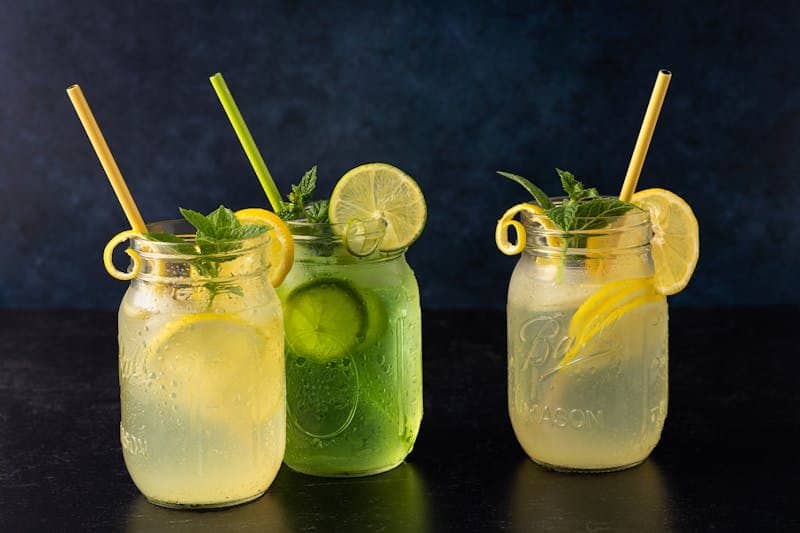Green Chile Lemonade -Three mason jars filled with lemon and lime refreshment garnished with mint.