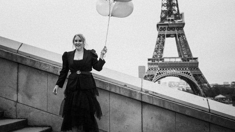 Woman holding a balloon in front of the Eiffel Tower