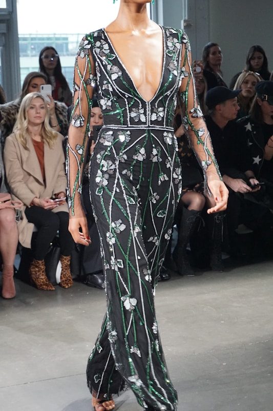 Woman in a long, floral-embellished black dress.