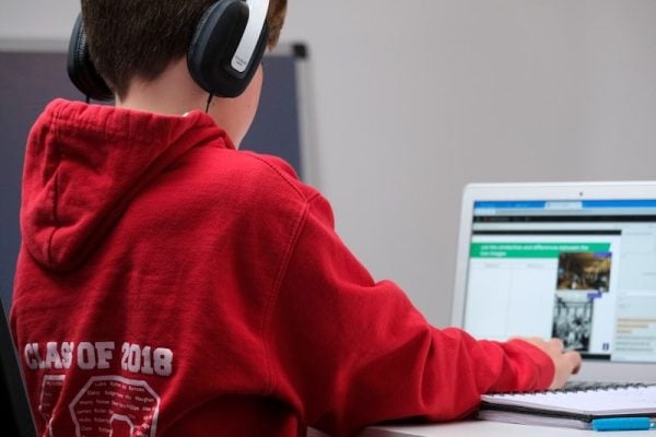 Remote schooling - boy in red hoodie wearing black headphones