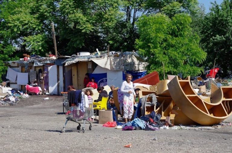 Makeshift homes with scattered belongings and debris.