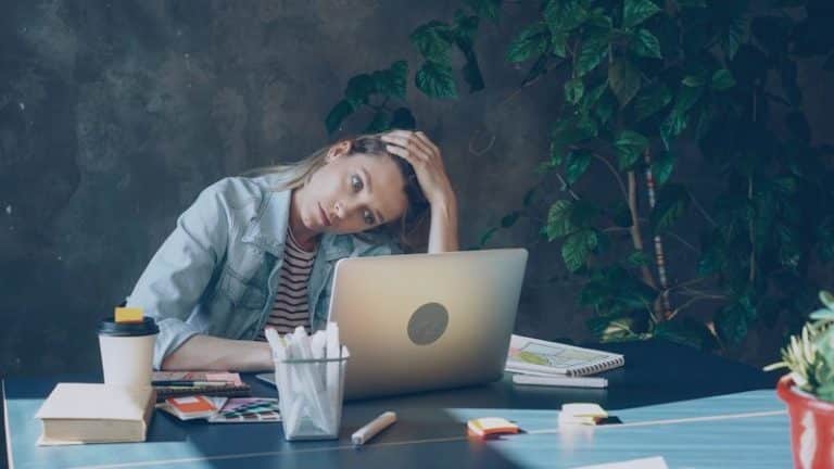 woman burnout appears stressed while working on laptop.