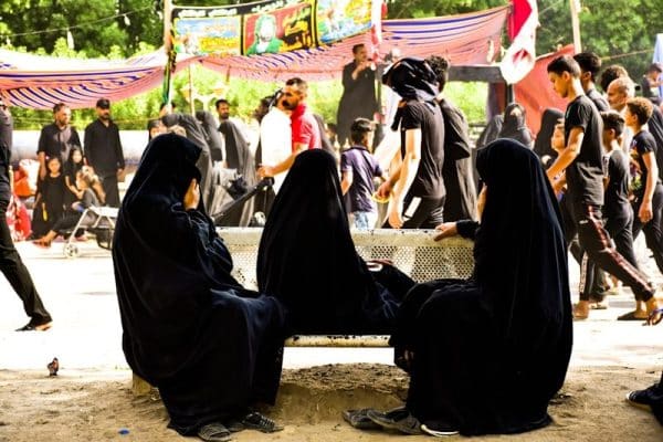 Western Feminists people sitting on brown concrete floor during daytime